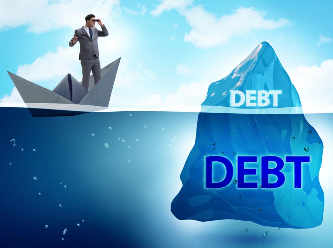 Businessman in a small boat facing an iceberg labeled ‘debt’ symbolizing hidden risk of unregulated debt consultants to Canadian insolvency. A comparative look at regulatory approaches by the UK and Australia regarding debt consultants, with implications for Canada