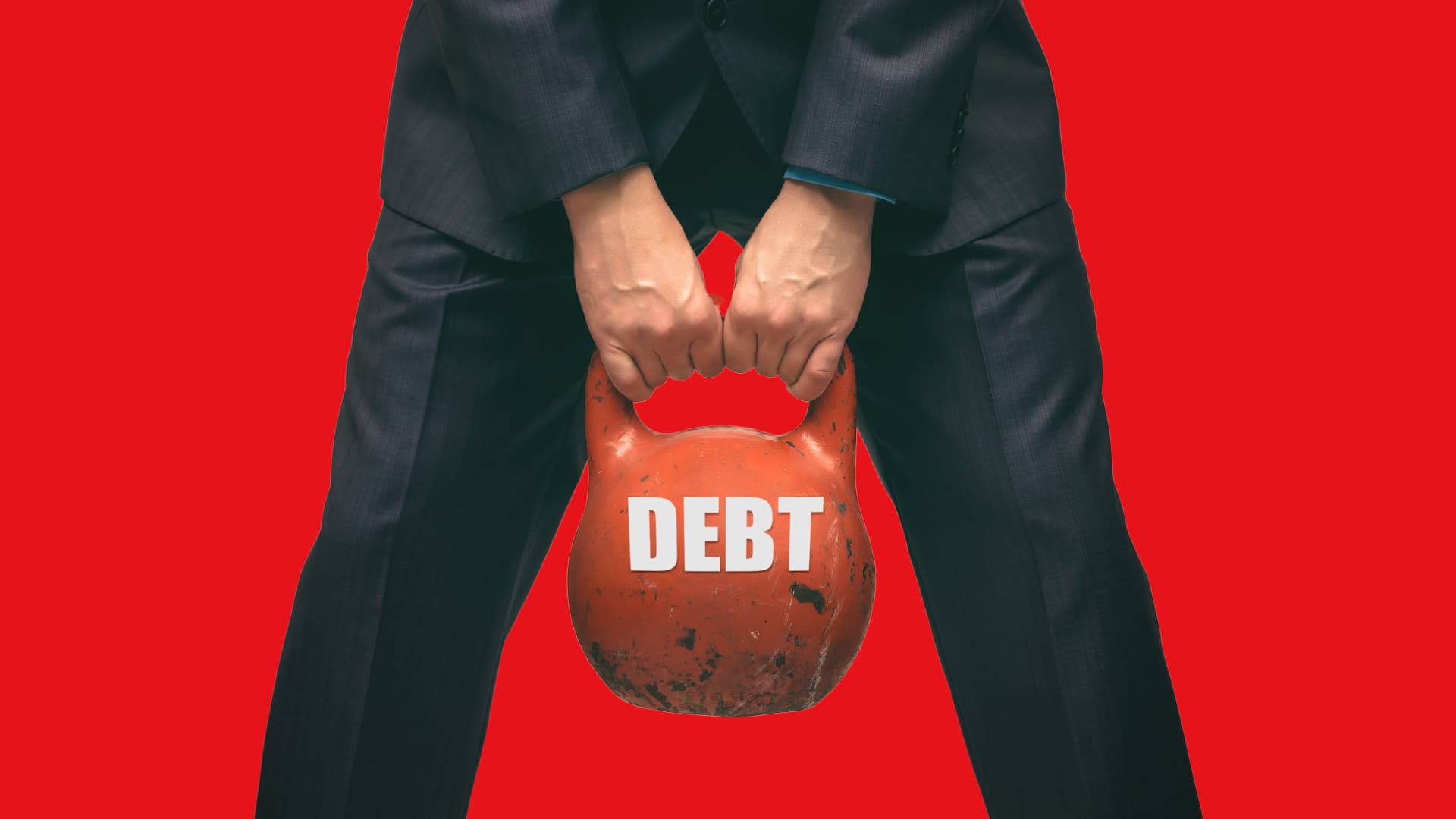 Businessman holding weight with the label 'debt', representing Canadian corporation directors facing GST/HST debt and financial stress