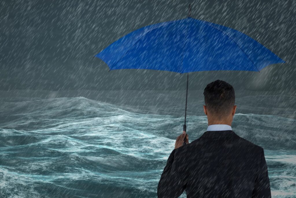 Silhouette of a man holding a blue umbrella, standing firm and facing a storm, symbolizing challenges to face in residential insolvency