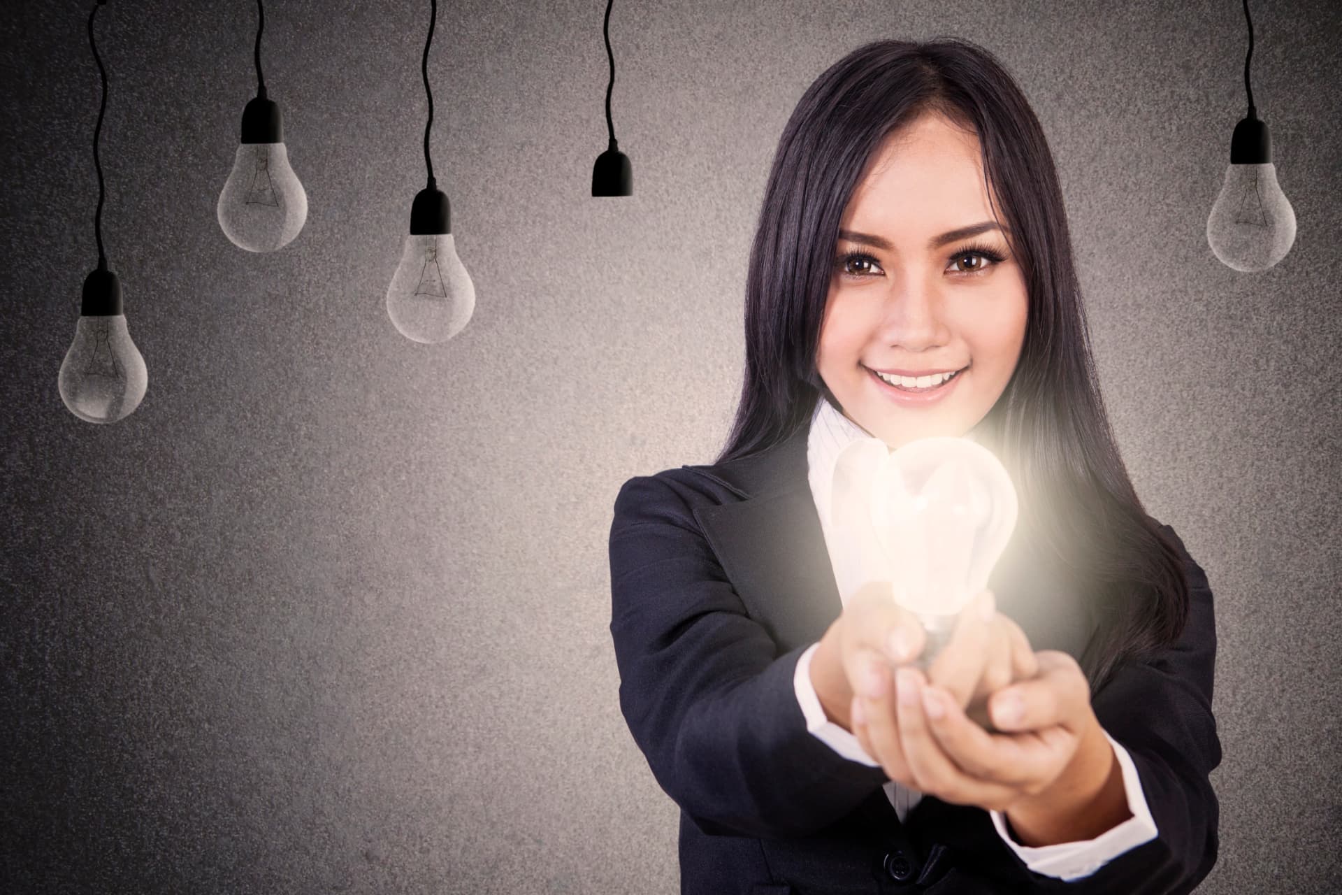 Canadian businesswoman presenting glowing lightbulb representing solutions for GST/HST tax debt and insolvency options