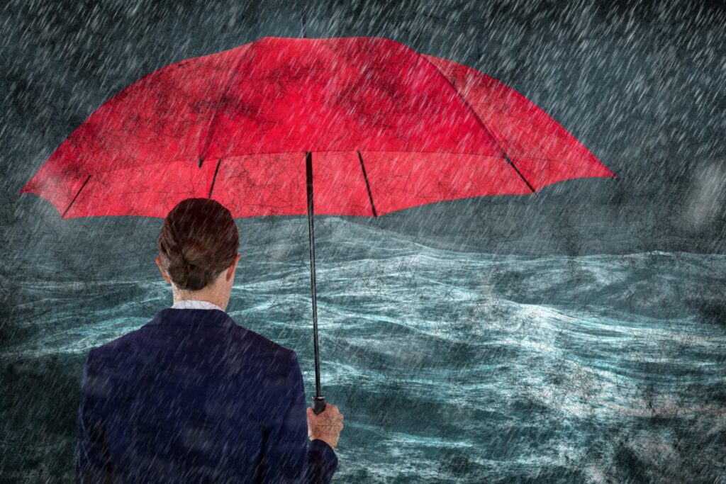 Silhouette of a business woman holding a blue umbrella, standing firm and facing a storm, symbolizing challenges to face in residential insolvency