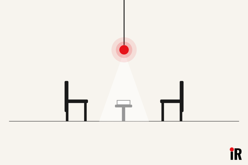 Minimalist vector illustration of two chairs facing each other across a small table with a document, under a single warm pendant light glowing red, in black, cream and white, representing what it's like to meet a Licensed Insolvency Trustee LIT